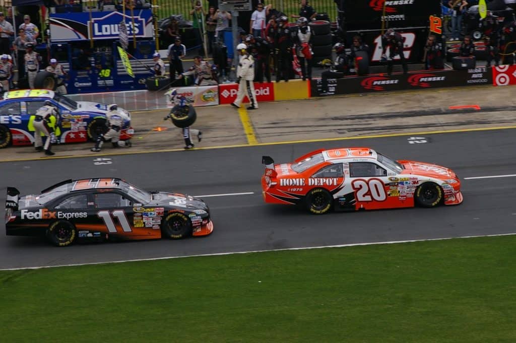 Denny Hamlin and Joey Logano driving down pit road in the 2009 Coca-Cola 600