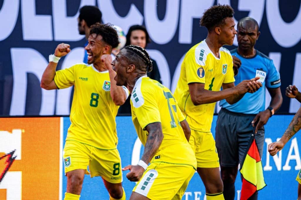 From left, Team Captain Sam Cox, midfielder Neil Danns, and midfielder Elliot Bonds of the Guyana National Team celebrate during their match versus Panama at the 2019 Gold Cup
