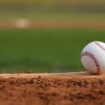 A baseball sitting on home plate of a baseball diamond