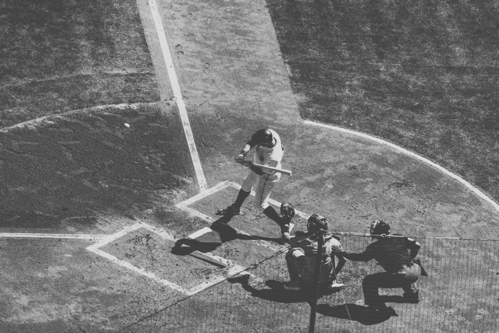 Black-and-white photograph of a baseball batter swinging at a pitch